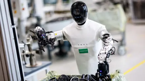 Schaeffler A robot from Humanoid sorts though a box of components in factory.