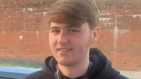 Family handout A young teen with short brown hair, wearing a black hoodie, smiles at the camera