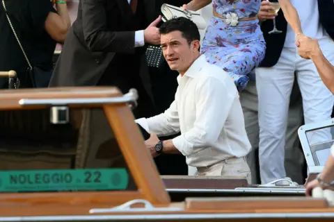 Getty Images British actor Orlando Bloom wearing a white shirt and cream-coloured trousers in Venice, Italy, for the wedding of Jeff Bezos and Lauren Sanchez.