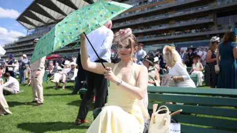 NEIL HALL/EPA/Shutterstock A woman with a parasol the first day of Royal Ascot.