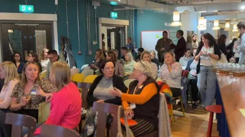 People sat in chairs talking to each other.