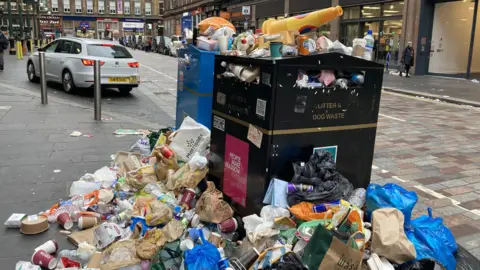 PA Media An overflowing bin in Glasgow