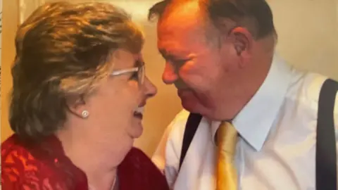 Supplied Catherine and Michael Curtis looking into each other's eyes and smiling. They are formally dressed.
