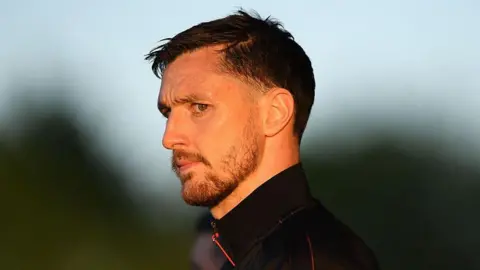 Dom Hyam looks on as he arrives at the ground