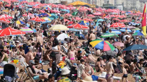 A very crowded beach with parasols and lots of people