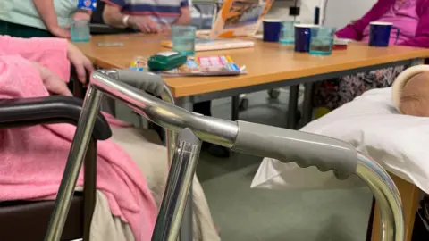 A walking frame is left beside elderly residents in a residential care home in Bristol