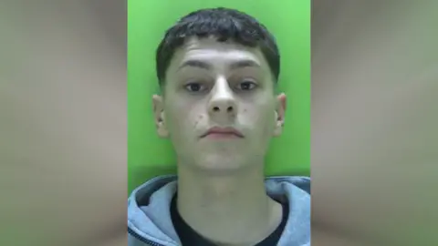 A police custody image of Harrison Cudworth against a green background