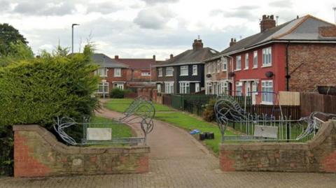 A path leading between a row of houses