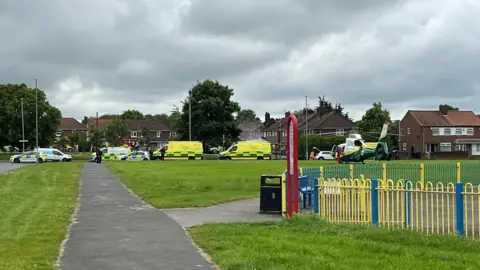 Police and ambulance vans near a play park