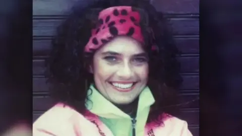 Handout The FTD brother's mum Geraldine. She has dark curly hair, wearing a pink headband and green and pink zip up jacket.