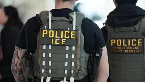Immigration and Customs Enforcement (ICE) agents patrol an airport