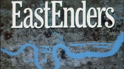 A screen grab of the EastEnders opening sequence with 'EastEnders' written in large, bold, white writing over a birds-eye view of the capital, with the river Thames running through it.