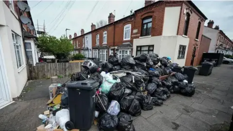 Getty Images A large pile of black bin bags in a residential street