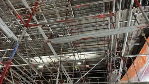 Chrissie Reidy/BBC Interior close up shot of lots of scaffolding covering the roof of the Orchard Theatre in Dartford 