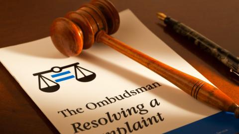 An ombudsman's report, gavel and pen