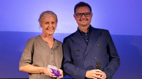 Janette Cardy and Tim Williams in front of a purple background