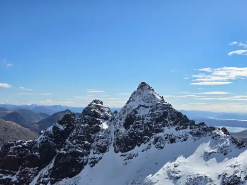 Jamie Bonini A snow covered peak with clear blue skies. 