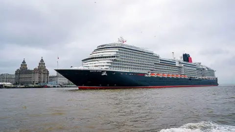 PA Media Cunard's Queen Anne sailing into the Mersey ahead of a naming ceremony at Liverpool Pier Head with the Royal Liver building in the background.