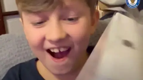 West Midlands Police Keaton Slater smiling and opening a present