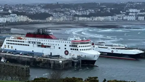 Two ferries sit in port of Douglas Sea Terminal on a grey day.