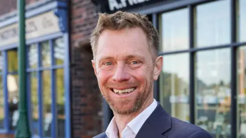 Black Country Living Museum A close-up of David Middlemiss, a man with dark hair and a beard, smiling at the camera.