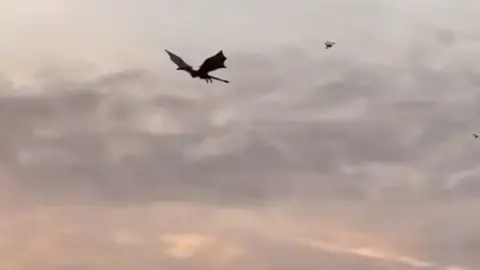 Dragon flies over Glasgow at sunrise