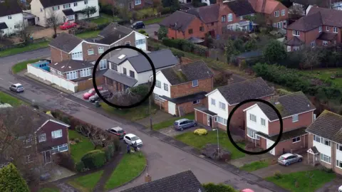 PA Media An aerial view of a residential street where two houses close to each other are marked by black circles.
