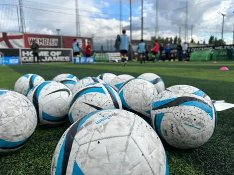 BBC/Harry Low Balls on astroturf with players in background