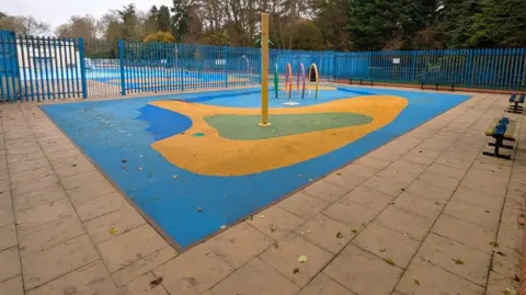 A blue and yellow play area with blue fencing around it