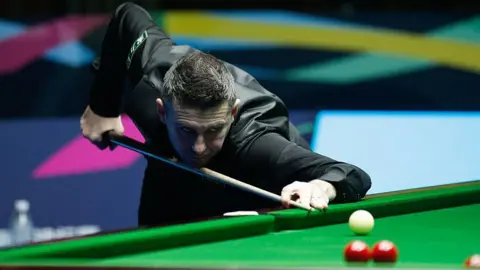 Mark Selby plays a shot