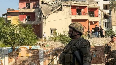 Reuters A Lebanese army soldier stands in front of a destroyed building in the city of Sidon, south Lebanon