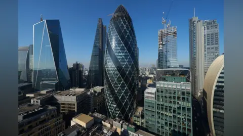 Getty Images A cylindrical glass skyscraper among a group of tall buildings in the City of London. 
