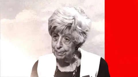 An elderly woman looks off to the left of the screen