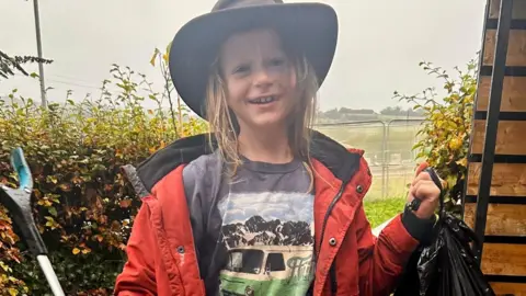 Family issue Theo holding one of the black bags filled with some of the 130kg of litter he has collected 