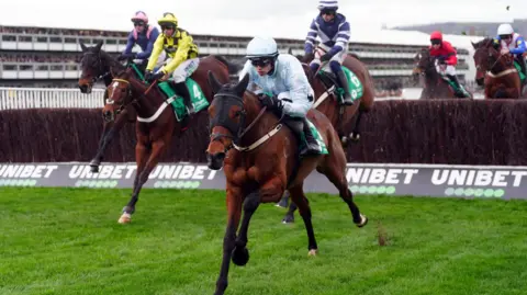 PA Four jockeys jump over a thick hurdle made of sticks. Kargese the horse, ridden by Danny Mullins, is front and centre on their way to winning the Singer Arkle Novices' Chase. 