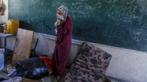 EPA Een ontheemde Palestijnse vrouw reageert nadat een Israëlische luchtaanval een deel van de door de VN geleide al-Jaouni-school in het vluchtelingenkamp Nuseirat, centraal Gaza, trof (11 september 2024)