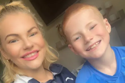 Handout Kirsty Slater, who has blonde hair, smiling in a photo with Joshua, who has short ginger hair.