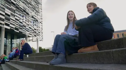 BBC/GEMMA LAISTER Two students beryllium   connected  factual  steps. One has agelong  brownish  hairsbreadth  and a airy  bluish  apical  and jeans. The 2nd  is wearing a achromatic  shiny jacket. In the inheritance  determination   are different   students sitting down. 