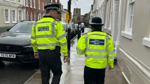 A police officer and a police community support office patrolling the streets