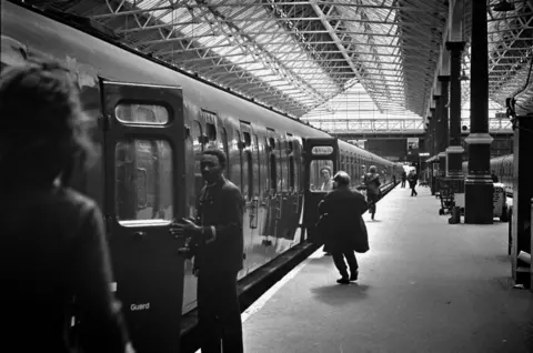 Passengers hurry to get on a train before it leaves