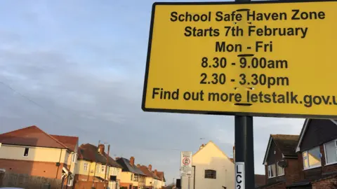 Google A yellow school zone sign