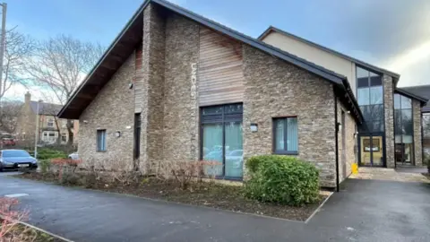 Google An exterior view of the Lanchester Medical Centre, a brick building with silver lettering reading the practice name on the wall.