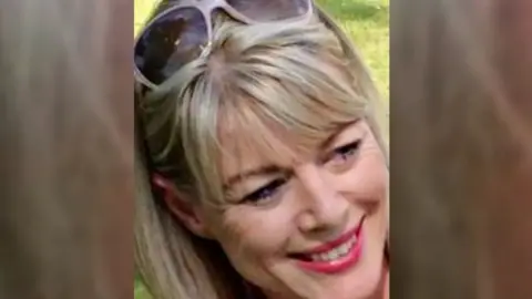 A family photo of Sarah Ashwell, who has blonde hair, red lipstick and sunglasses on her head.