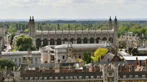 A view of King's College chapel in Cambridge, with trees behind and other Cambridge University buildings in front