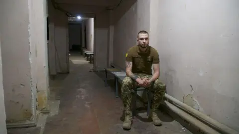 Thanyarat Doksone/BBC Vlad sits on his own in a dingy corridor