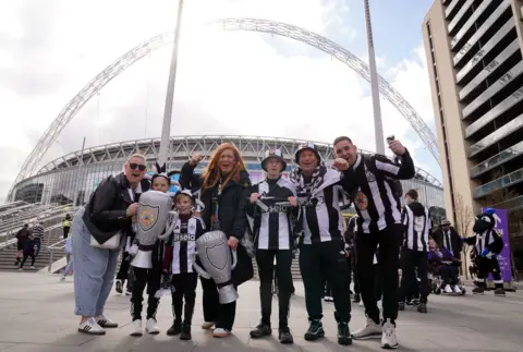 Owen Humphreys/Pa Media Sebuah keluarga dengan anak -anak yang mengenakan atasan Newcastle United di luar Wembley.