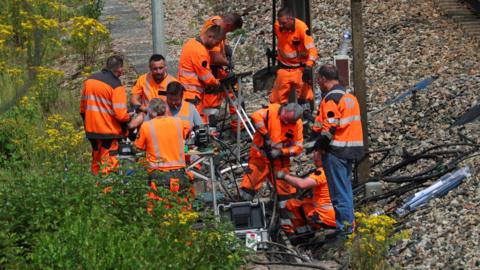 SNCF railway workers work at the site where vandals targeted France's high-speed train network 