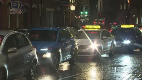 Traffic congestion in Belfast city centre in December last year. Four cars are queued closely together, two of them taxis with yellow signs