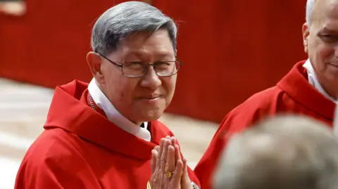 EPA Cardinal Luis Antonio Tagle in red vestment has greying hair and is wearing spectacles