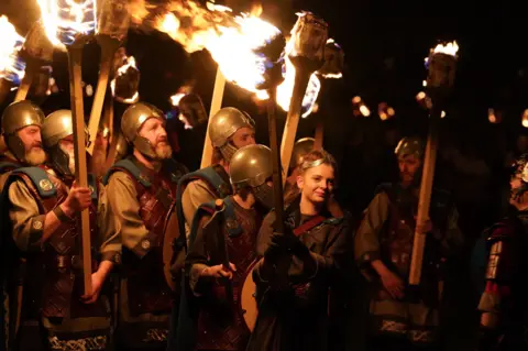 PA Media The Jarl Squad lit the galley during the celebration in Lerwick